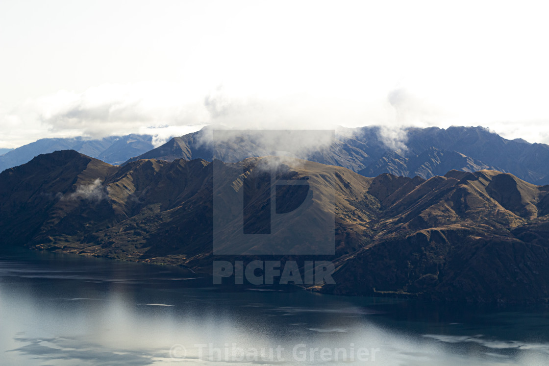 Mountains reflection over the lake on a bright cloudy day